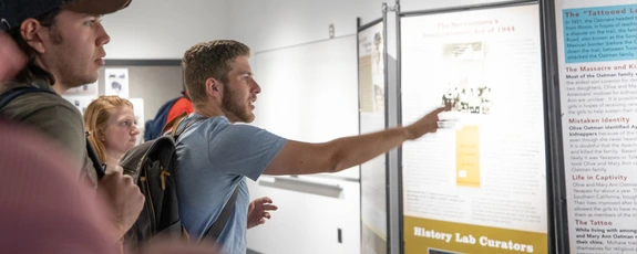 Undergraduates looking at history display